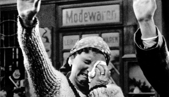 Mulher em Praga chorando enquanto faz a saudação nazi